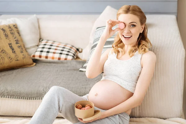 Schwangere begeistert Frau posiert mit Makronen — Stockfoto