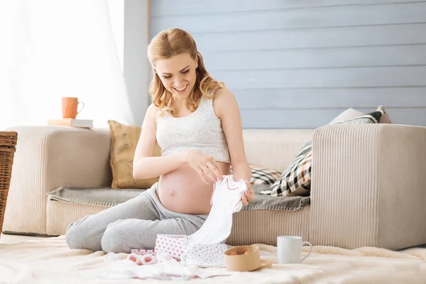 Gravid kvinna att upptäcka babykläder — Stockfoto