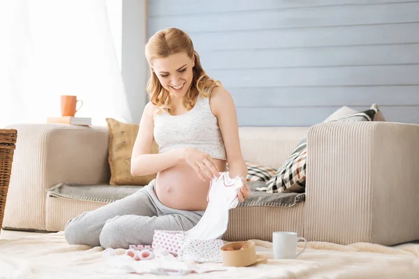 Donna incinta alla scoperta di vestiti per bambini — Foto Stock