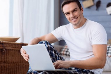Bir dizüstü bilgisayar kullanarak hoş genç adam
