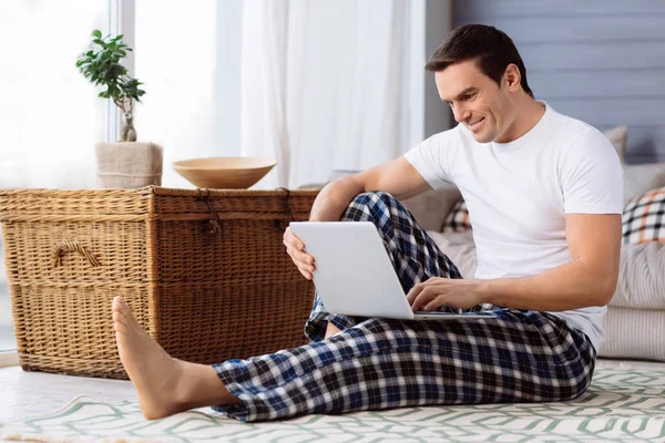 Dizüstü bilgisayar ekranına bakarak mutlu yakışıklı adam