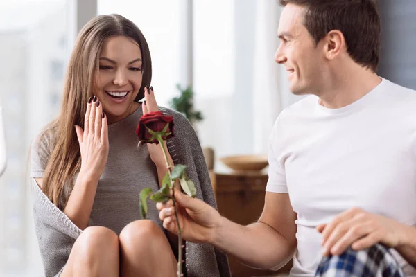 Bonito bom homem dando uma flor para sua namorada — Fotografia de Stock