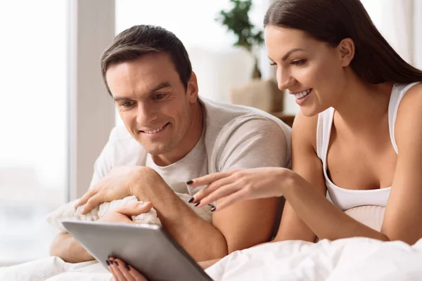 Joven pareja alegre usando una tableta —  Fotos de Stock