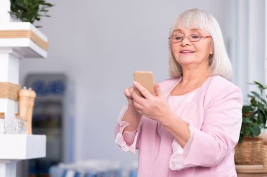 Telefonunu kullanarak heyecanlı üst düzey kadın