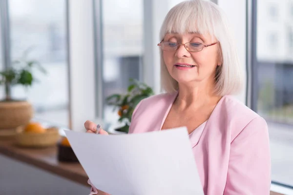 Femme d'affaires sérieuse examinant un document — Photo