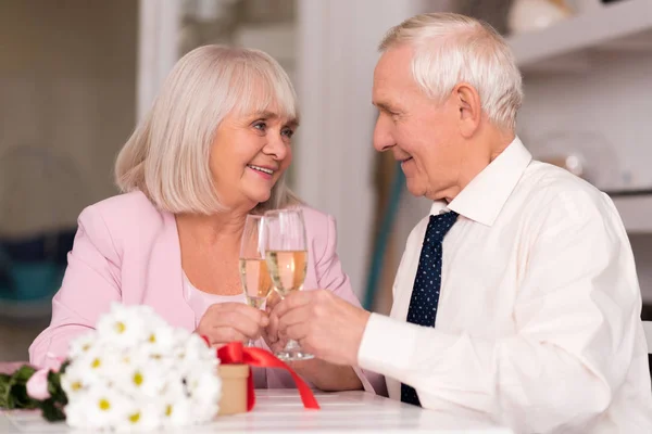 Alegre pareja de ancianos levantando sus gafas para amar — Foto de Stock