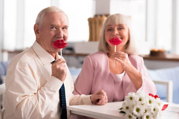 Очаровательная пожилая пара с красными леденцами — стоковое фото