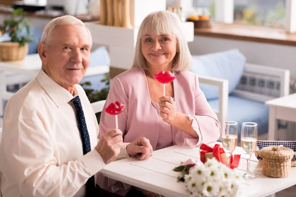 Encantadora pareja de ancianos posando con caramelos — Foto de Stock