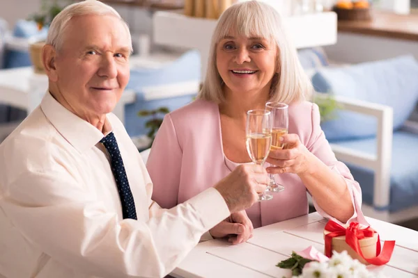 Couple of cute elderly people drinking champagne — Stock Photo, Image