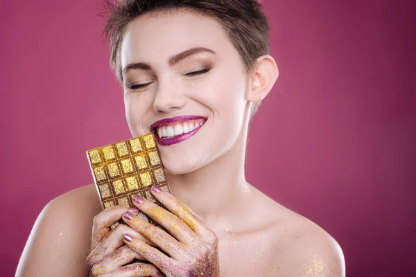 Mulher alegre segurando bar de chocolate — Fotografia de Stock