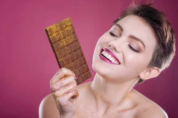 Gioioso modello felice in posa con barretta di cioccolato — Foto Stock