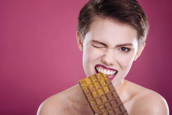 Mulher agradável comer barra de chocolate — Fotografia de Stock