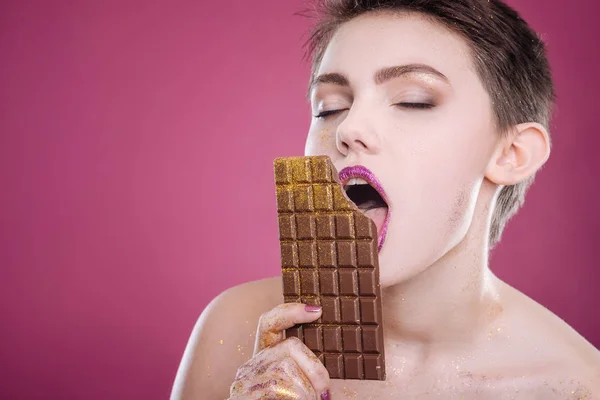 Mujer encantada comiendo barra de chocolate — Foto de Stock