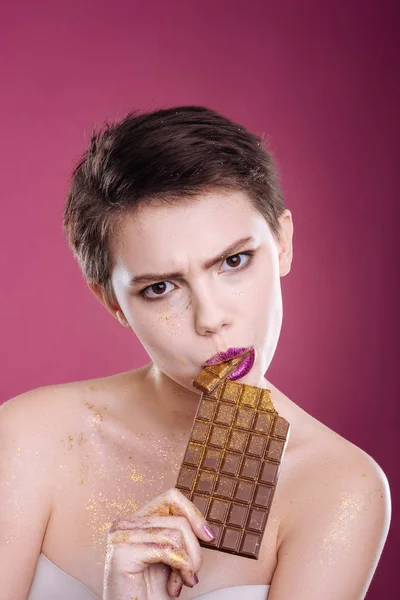 Involved woman eating chiocolate bar — Stock Photo, Image