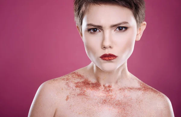 Serious woman posing against pink background — Stock Photo, Image