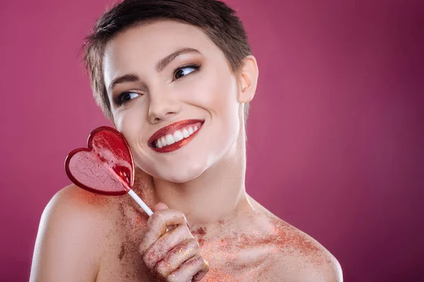 Bonita mujer sonriente posando con piruleta — Foto de Stock