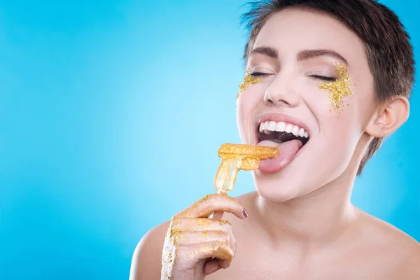 Cheerful woman eating lollipop — Stock Photo, Image