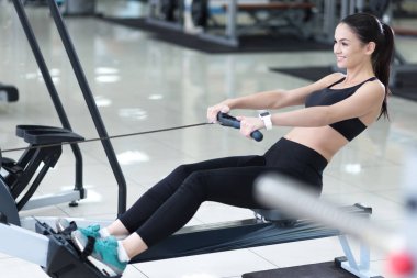 Happy woman spending time in a gym clipart