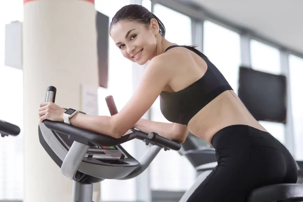 Усміхнена дівчина використовує бігову доріжку в спортзалі — стокове фото