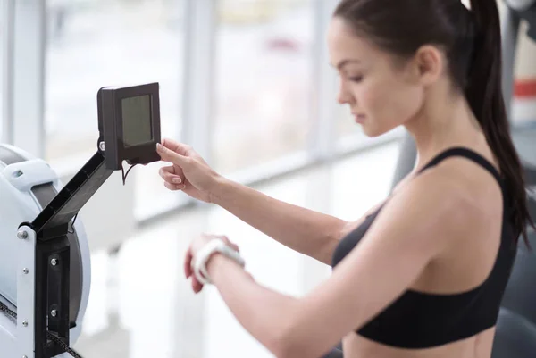 Mädchen kontrolliert Gewicht und Puls im Fitnessstudio — Stockfoto