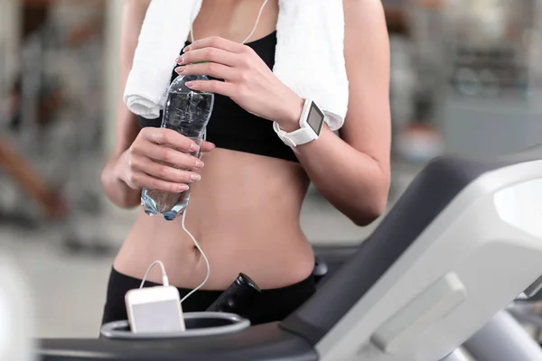 Chica delgada sosteniendo una botella de agua después del entrenamiento — Foto de Stock