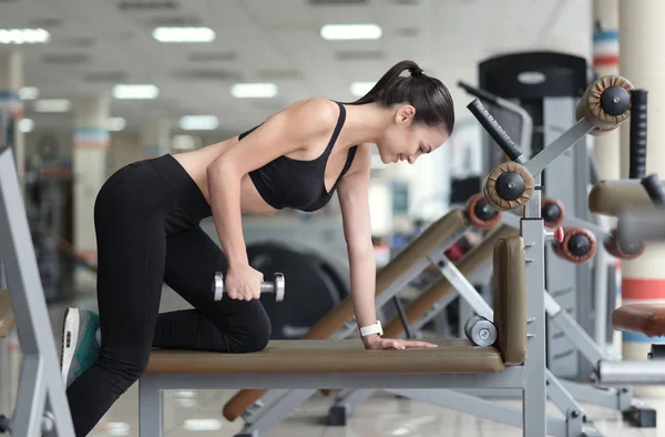 Lachende meisje uit te werken op een trainer — Stockfoto