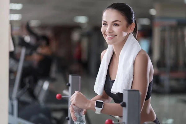 Delighted girl relaxing after training in a gym — Stock Photo, Image