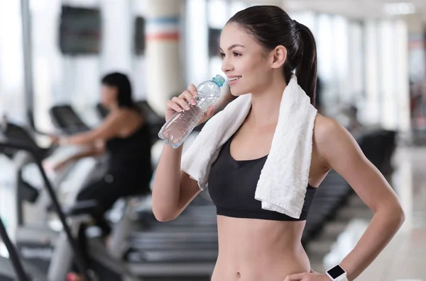 Delighted girl drinking water after training — Stock Photo, Image