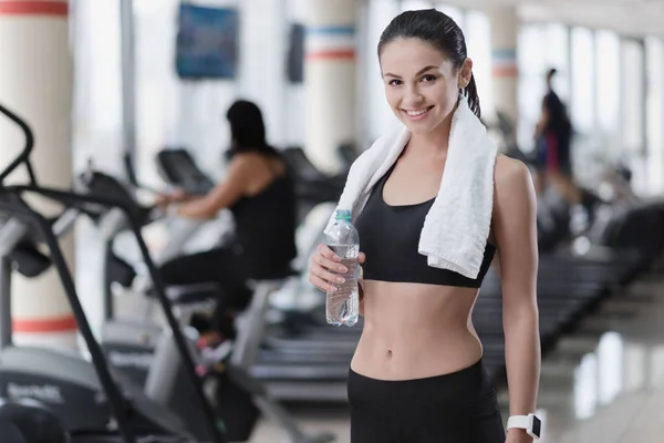 Smiling girl posing with a towel in gym — Stock Photo, Image
