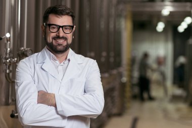 Gülümseyen adam bira fabrikasında poz
