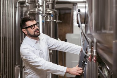 Fabrika üzerinde çalışan yakışıklı adam