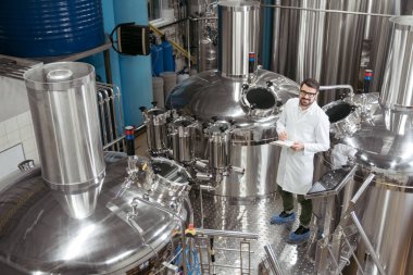 Gülümseyen adam makine bira fabrikası'nda ayakta