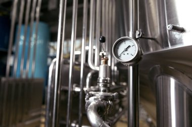 Measuring gauge being used in brewery clipart