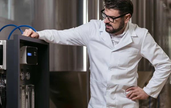 Handsome man controlling brewing mechanism — Stock Photo, Image