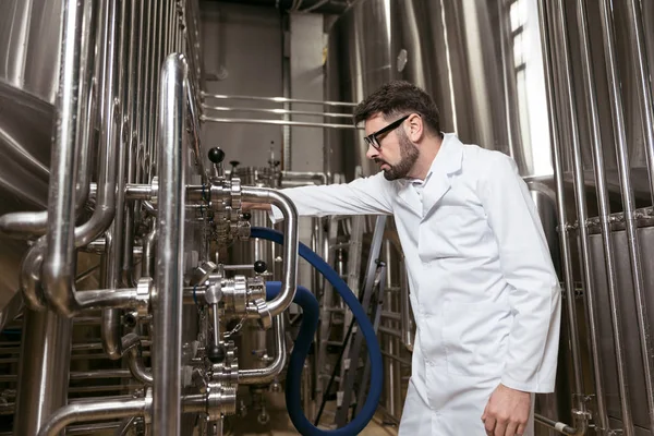 Concentrated man working with brewing mechanism — Stock Photo, Image