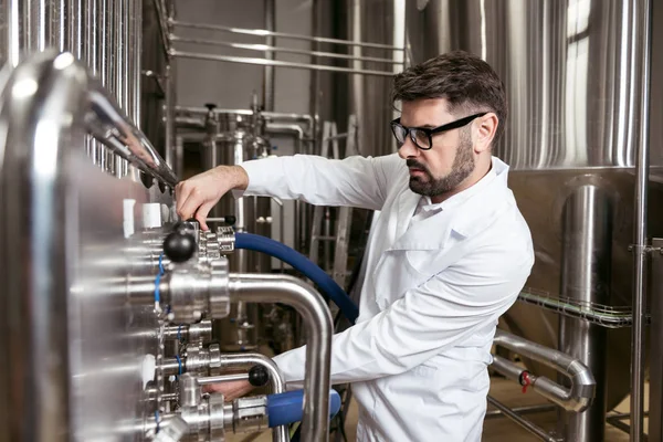Uomo intelligente utilizzando il meccanismo di produzione della birra — Foto Stock
