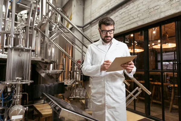 Concentrated man standing at beer factory — Stock Photo, Image