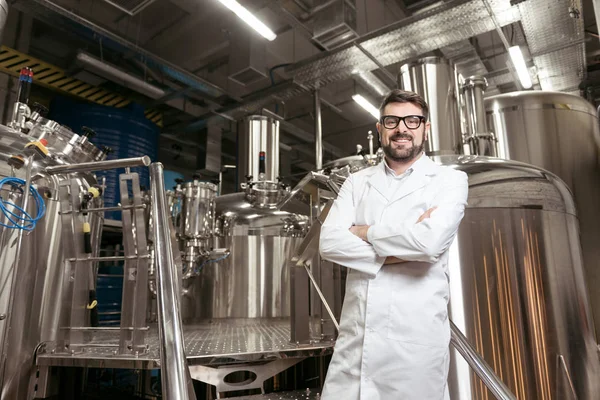 Uomo allegro in posa con meccanismi di produzione della birra — Foto Stock