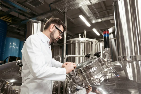 Concentrated man looking at brewing mechanism — Stock Photo, Image