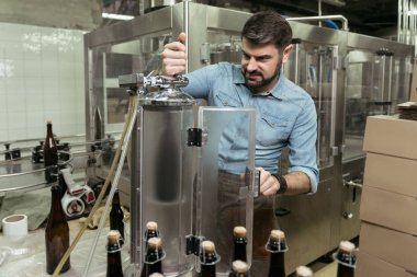 Sert bira fabrikasında çalışan erkeğin konsantre