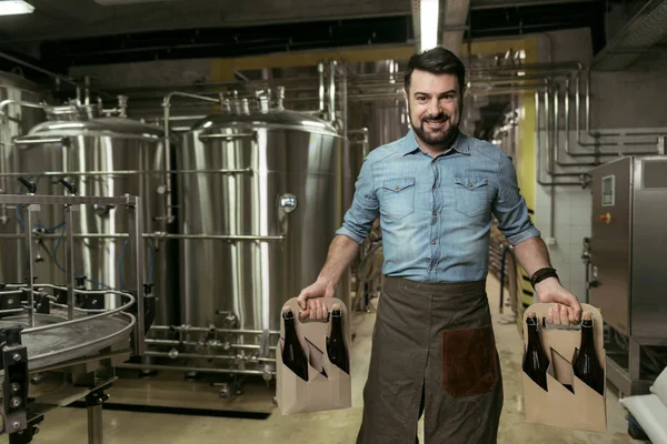 Gelukkig man houden van flessen alcohol in de brouwerij — Stockfoto