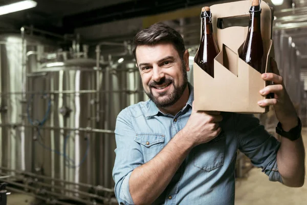 Uszczęśliwiony mężczyznę trzymającego butelek alkoholu w browarze — Zdjęcie stockowe