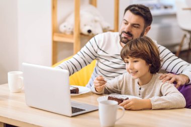 Küçük çocuk yemek yerken film izlemek