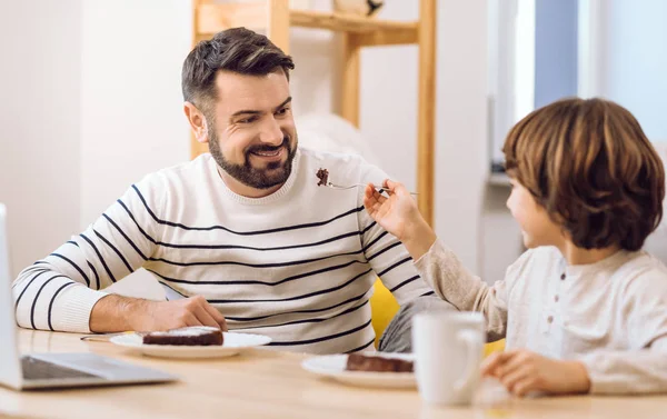 Feliz familia sonriente comiendo juntos — Foto de Stock