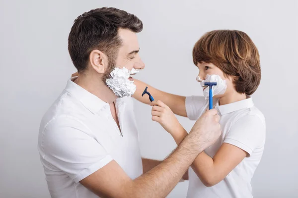 Радостный мужчина и мальчик собираются побриться — стоковое фото