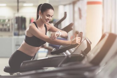 Gülümseyen kız bir spor salonunda onun sonuçlarını denetleme