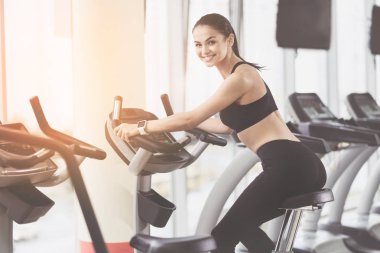 Gülümseyen kadın spor salonunda antrenör kullanarak