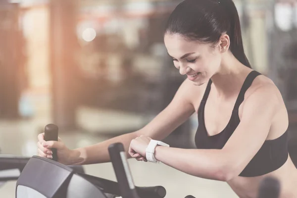 Mujer encantada controlando su pulso en un gimnasio — Foto de Stock