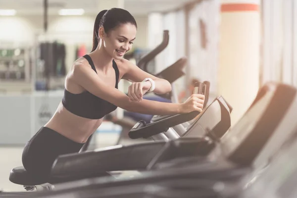 Lachende meisje beheersing van haar resultaten in een sportschool — Stockfoto