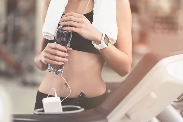 Egzersiz yaptıktan sonra bir şişe tutan ince kadın — Stok fotoğraf